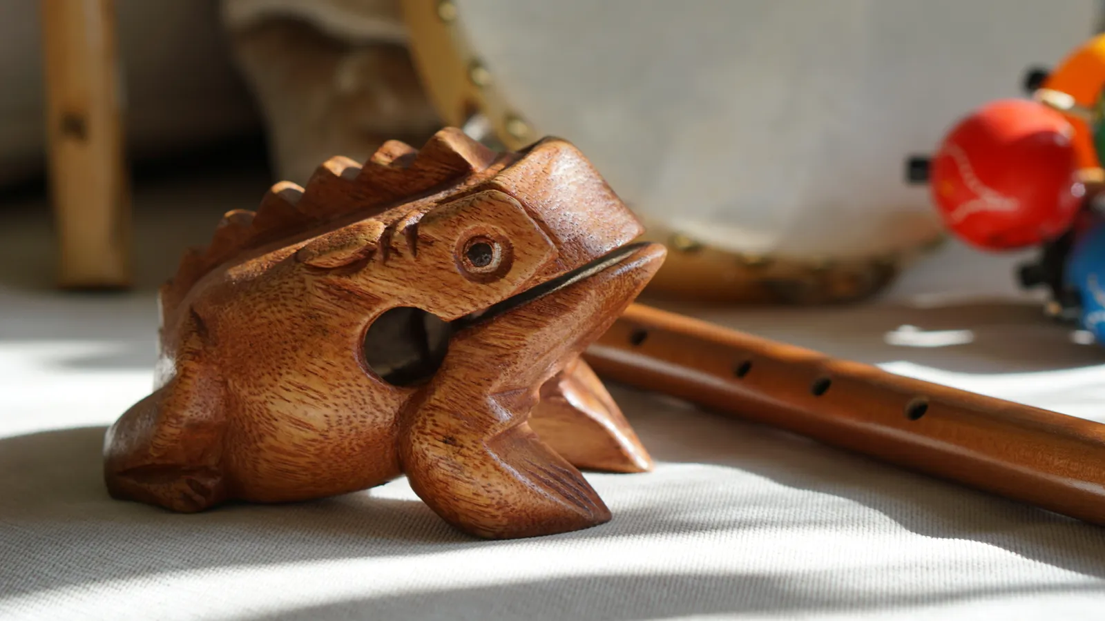 Hölzerner Klangfrosch und Flöte im Sonnenlicht